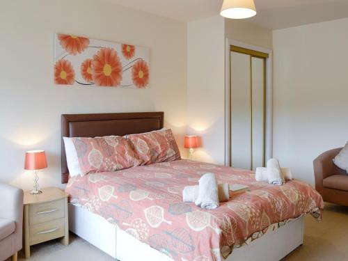een slaapkamer met een bed met twee knuffels erop bij Pennan Lodge - 26818 in Pennan