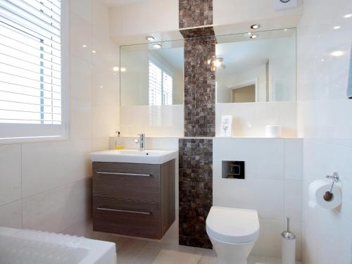 a bathroom with a toilet and a sink and a mirror at The Avoncliffe Bournemouth in Southbourne