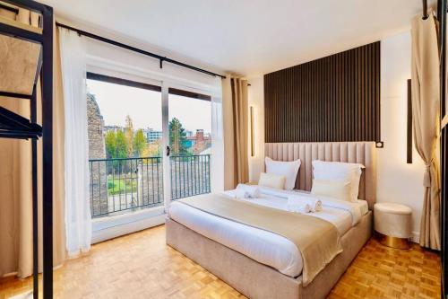 une chambre avec un grand lit et une grande fenêtre dans l'établissement Family 3 BDR near St Germain, à Paris