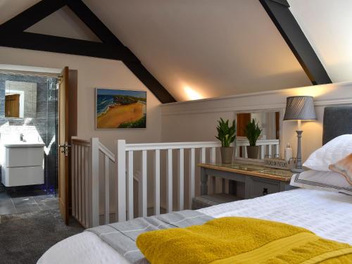 a bedroom with a bed and a desk at Apple Barn Cottage in Brixham