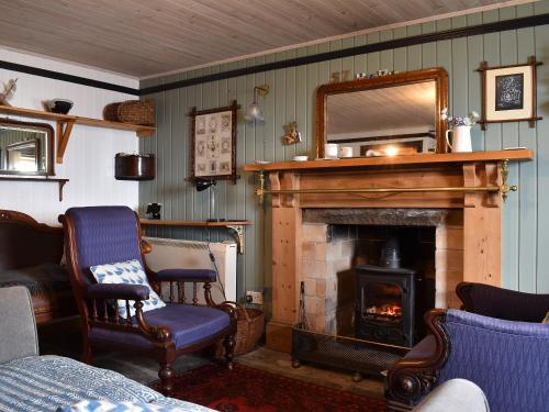 a living room with a fireplace and a mirror at Crovie in Gardenstown