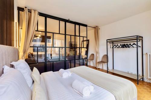 une chambre avec un grand lit avec des draps et des oreillers blancs dans l'établissement Family 3 BDR near St Germain, à Paris