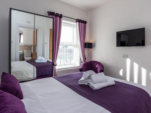 a bedroom with a large bed and a mirror at The Cliff Top, Torquay in Torquay