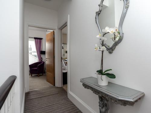 a hallway with a table and a mirror at The Cliff Top, Torquay in Torquay