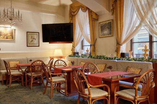 restauracja ze stołami i krzesłami oraz telewizorem w obiekcie FLEUR DE LIS HOTEL w Pradze