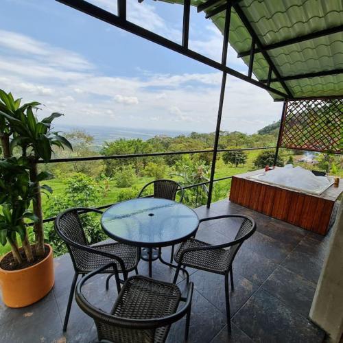 比亞維森西奧的住宿－glamping la cumbre，美景庭院里的玻璃桌子和椅子