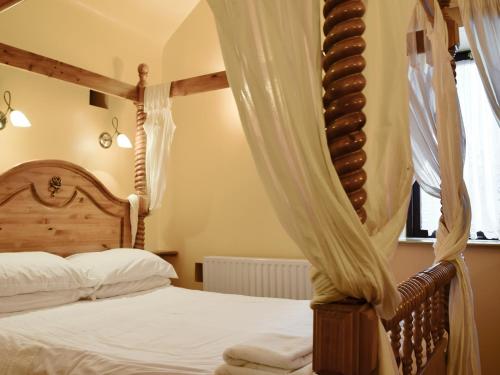 The Stable - B6205 في Onecote: غرفة نوم مع سرير مظلة ونافذة