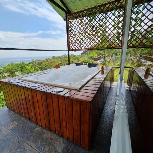 un bain à remous installé au-dessus d'une terrasse en bois dans l'établissement glamping la cumbre, à Villavicencio