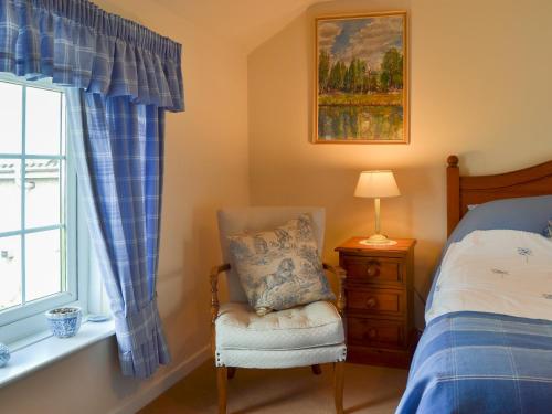 キングトンにあるMavis Cottageのベッドルーム1室(ベッド1台、椅子、窓付)