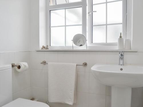 キングトンにあるMavis Cottageのバスルーム(洗面台、トイレ付)、窓が備わります。