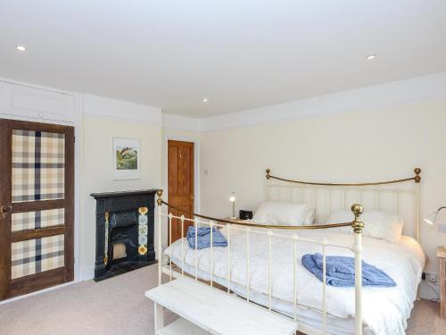 a bedroom with a bed and a fireplace at Lapwing in Yarmouth