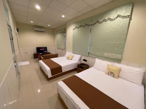 pokój hotelowy z 2 łóżkami i telewizorem w obiekcie Rimin Hostel w mieście Nanxi