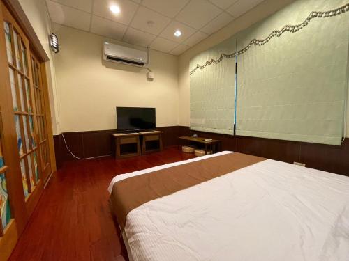 Pokój szpitalny z łóżkiem i telewizorem w obiekcie Rimin Hostel w mieście Nanxi