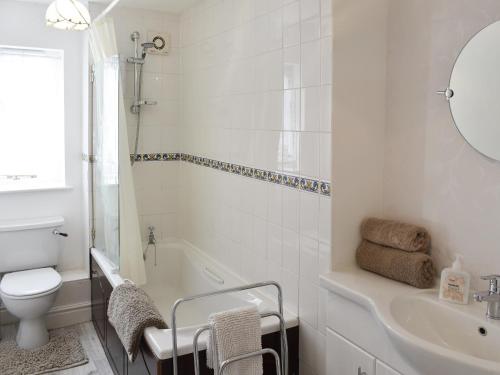 a bathroom with a tub and a toilet and a sink at Stybarrow View Cottage in Glenridding