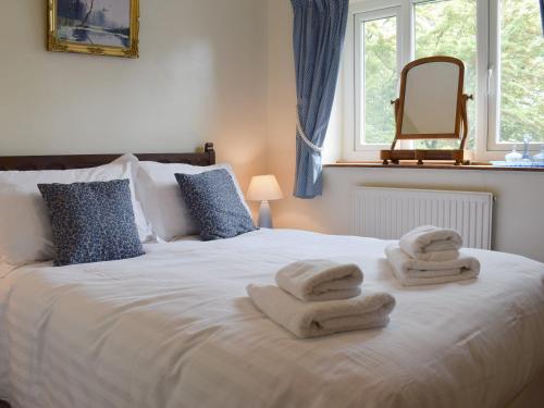 - une chambre avec un lit et des serviettes dans l'établissement Stable Cottage, à Windermere