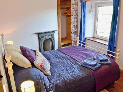 a bedroom with a bed with two towels on it at Trecarne Cottage in Saint Cleer