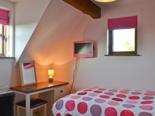 1 dormitorio con 1 cama y TV en una mesa en Maytree Cottage en East Dereham