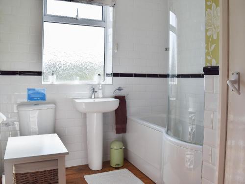 a bathroom with a sink and a toilet and a bath tub at Chorlton Moss Cottage in Maer