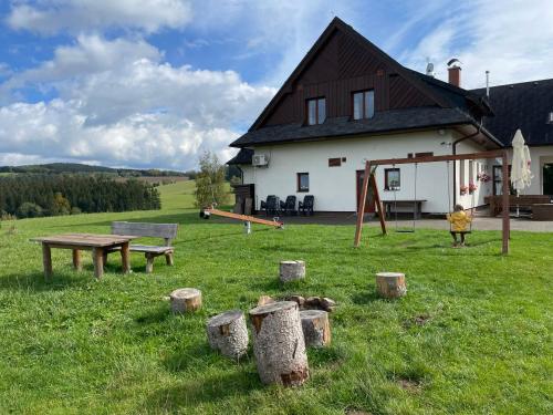 a house with a picnic table and a playground at Penzion Pod Dratnikem in Svratka