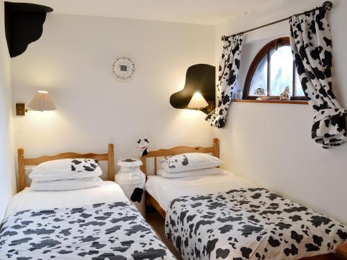 two beds in a room with black and white curtains at The Coach House in Tytherton Lucas