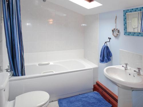y baño con bañera, aseo y lavamanos. en Craigdarroch Cottage en Strathyre