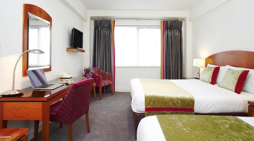Habitación de hotel con 2 camas y escritorio con ordenador en Lancaster Lodge en Cork