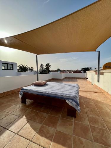 ein Bett auf dem Dach eines Hauses in der Unterkunft Pura Vida Surf Camp & School in La Oliva