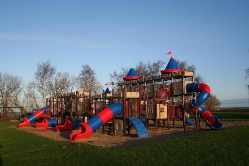 a playground in a park with a bunch of slides at Ostsee Ferienhäuser in Waabs