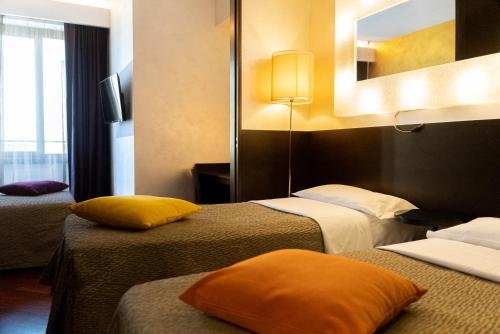 a hotel room with two beds and a mirror at Hotel Re Di Roma in Rome