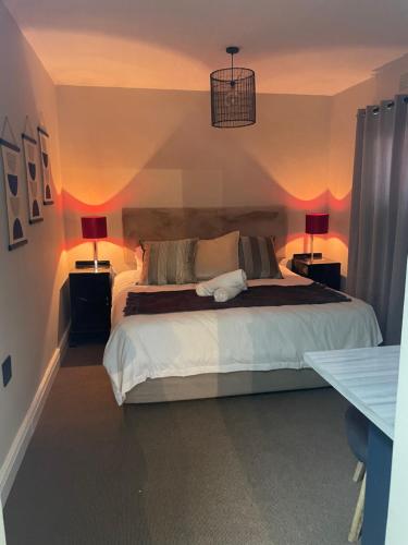 Mount Road Suites في بورت اليزابيث: غرفة نوم بسرير كبير فيها مصباحين