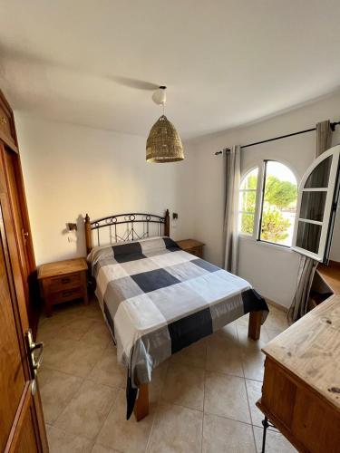 1 dormitorio con cama y ventana grande en Pura Vida Surf Camp & School, en La Oliva