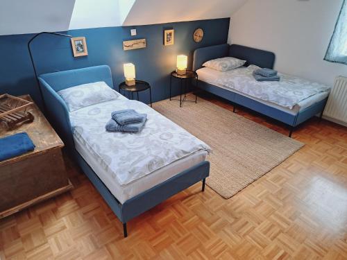 twee bedden in een kamer met twee tafels en twee lampen bij House Pucnk-beautiful countryside in Železniki
