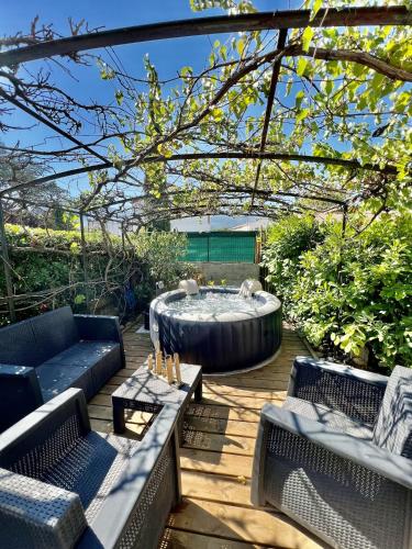 un patio avec une fontaine, des chaises et une table dans l'établissement Les orangers - Villa catalane avec Jacuzzi, à Saint-Génis