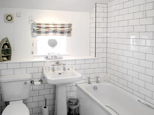シーハウシズにあるSpinneyの白いバスルーム(洗面台、トイレ、バスタブ付)
