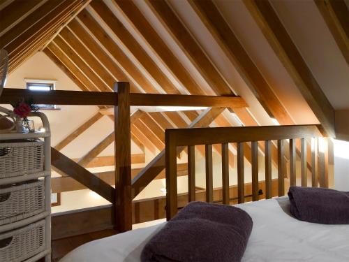 a attic room with a bed and a staircase at The Cowstall in Framfield
