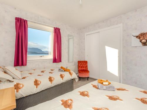 a bedroom with two beds and a window at West Home in Torridon