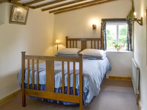 a bedroom with a bed and a window at Boundstone Farmhouse in Littleham