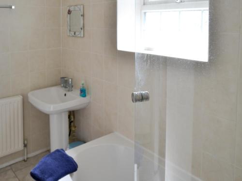 a bathroom with a shower and a toilet and a sink at Dune Cottage in Caister-on-Sea