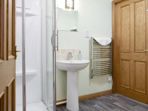 a bathroom with a white sink and a shower at White Wisp in Kinross