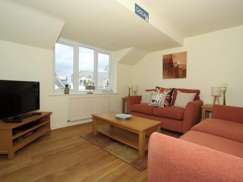 a living room with a couch and a tv at Watermark in Saint Columb Minor