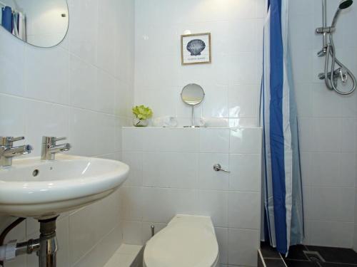 a white bathroom with a sink and a toilet at Watermark in Saint Columb Minor