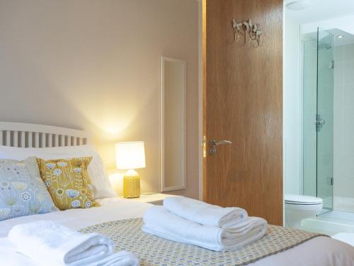 1 dormitorio con 1 cama con toallas en Ocean Serenity, Horizon View, en Westward Ho