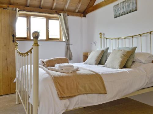 1 dormitorio con 1 cama blanca con sábanas y almohadas blancas en The Dairy en Arlingham