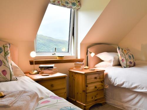 a bedroom with two beds and a window at Carron View in Strathcarron