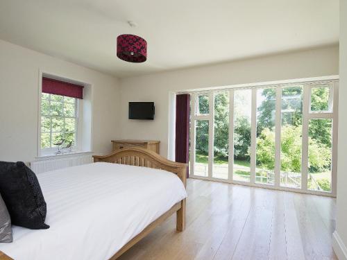 - une chambre avec un lit blanc et de grandes fenêtres dans l'établissement Curlew Barn, à Sutton Bridge