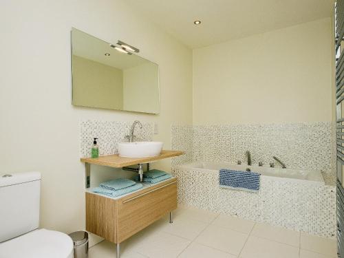 a bathroom with a sink and a bath tub at Curlew Barn in Sutton Bridge