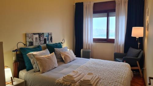 1 dormitorio con cama con almohadas y ventana en Apartamento vista Douro e Mar, en Oporto