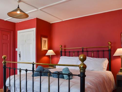 a bedroom with red walls and a bed at Seaspray in Camber
