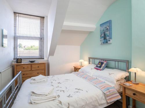 a bedroom with two beds and a desk and a window at Porto Seguro in Brixham
