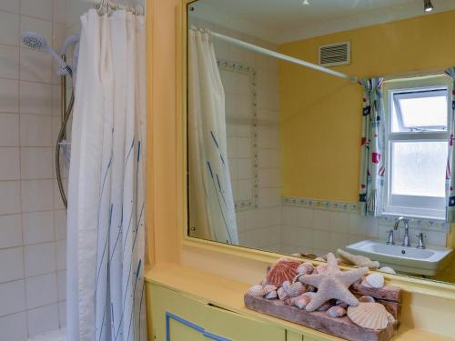 a bathroom with a sink and a mirror at Seaspray in Camber